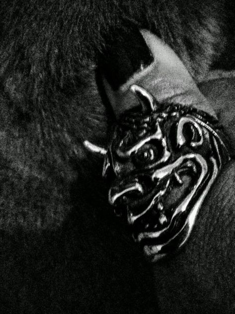 A high contrast black and white photo of my thumb with an oni ring, caressing a dark cat's fur.